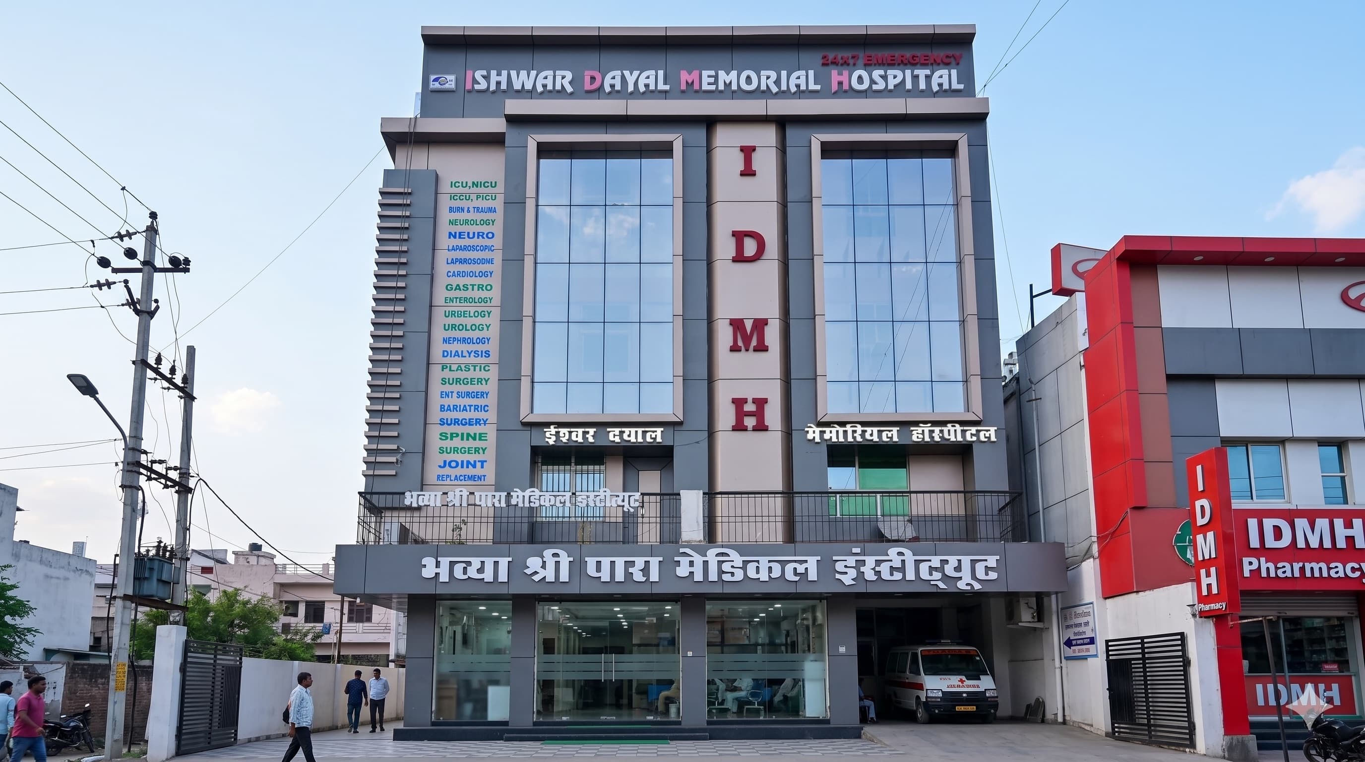 Ishwar Dayal Memorial Hospital (IDMH) building exterior with 24x7 emergency signage and department listing
